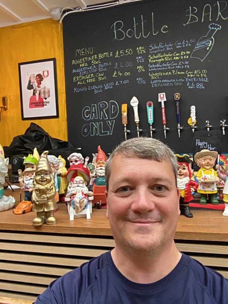 Man in front of garden gnomes in a pub