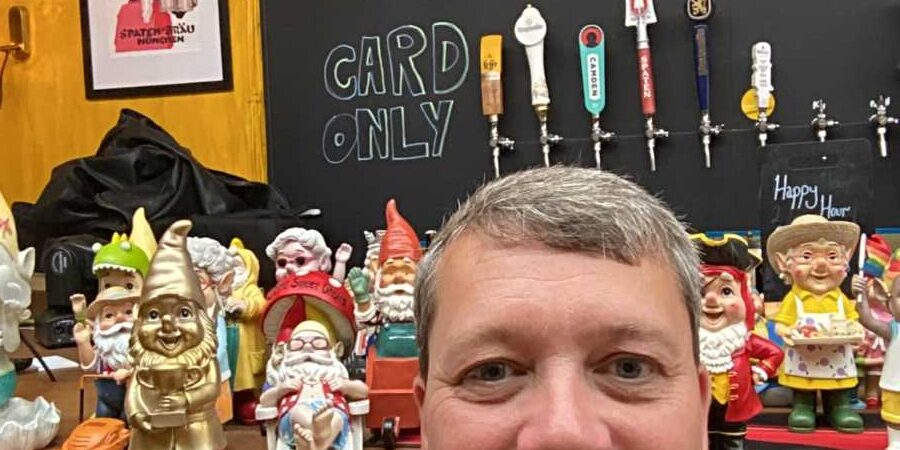Man in front of garden gnomes in a pub